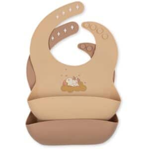 Beige silicone baby bib with a front pocket to catch food and a small cartoon bunny on a cloud design, adjustable with snaps on the neckband.